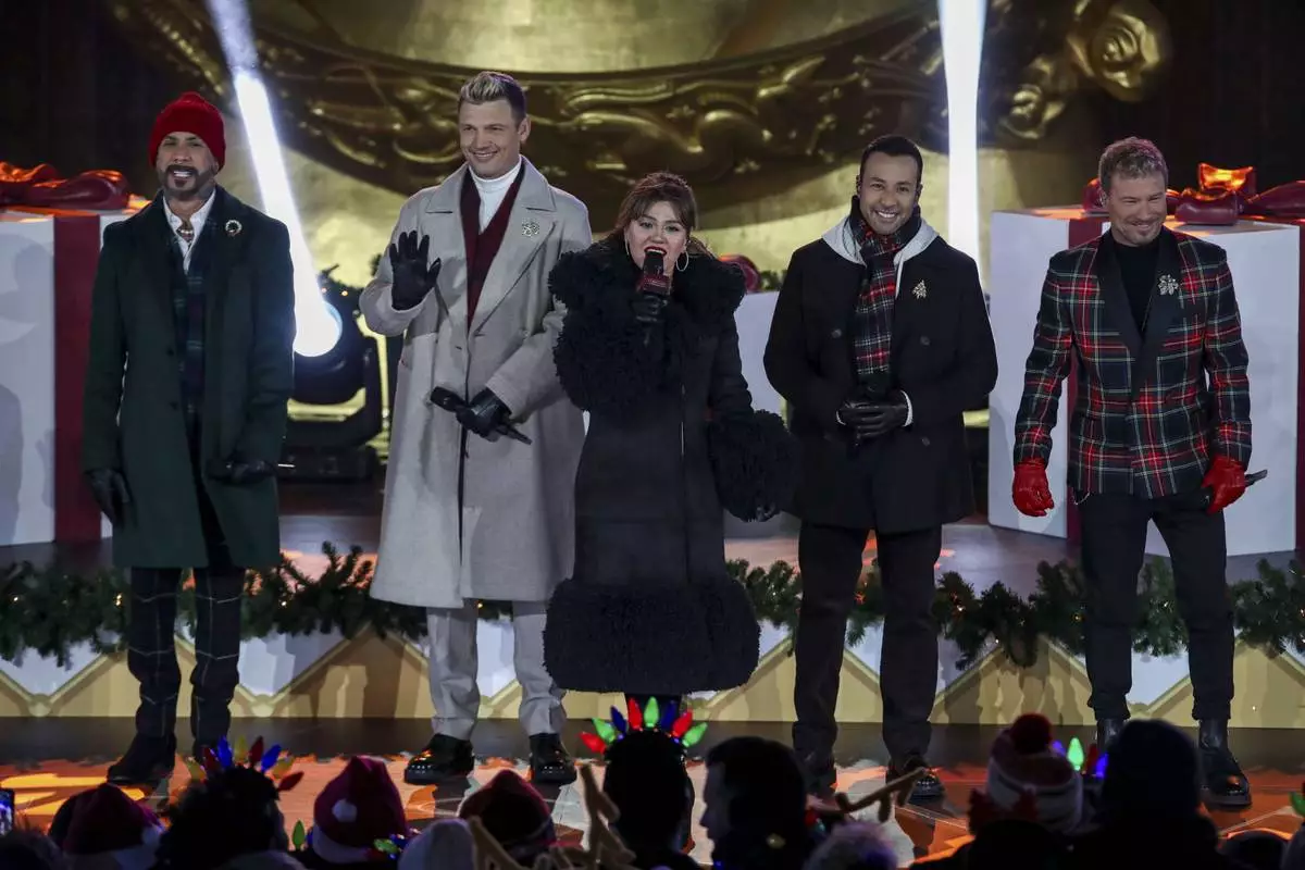 Singers AJ McLean, from left, Nick Carter, Kelly Clarkson, Howie Dorough and Brian Littrell participate in the Rockefeller Center Christmas tree lighting ceremony on Wednesday, Dec. 4, 2024, in New York. (Photo by Andy Kropa/Invision/AP)