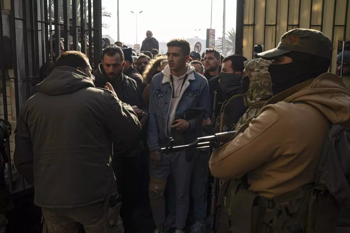 Members of Bashar Assad's army or a pro-government militia, gather to be registered with Syrian rebels as part of an "identification and reconciliation process" in Damascus, Syria, Saturday, Dec. 21, 2024. (AP Photo/Leo Correa)