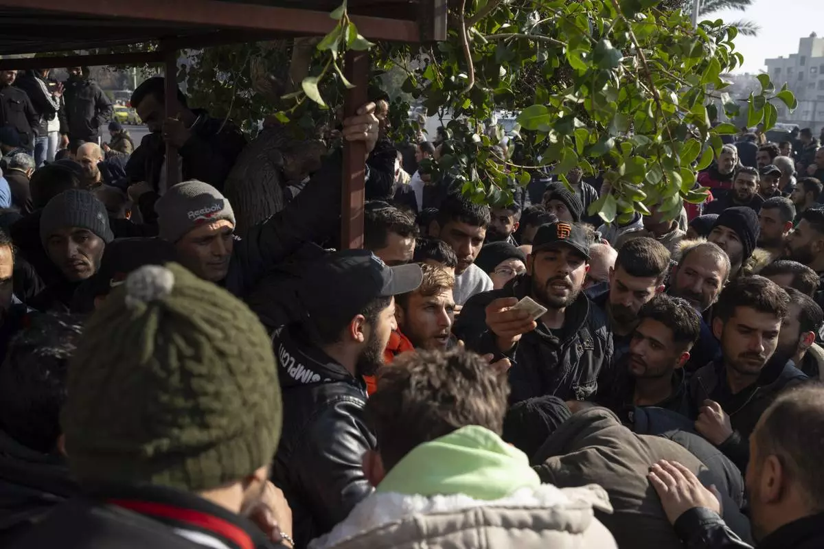 Members of Bashar Assad's army, or a pro-government militia, gather to be registered with Syrian rebels as part of an "identification and reconciliation process" in Damascus, Syria, Saturday, Dec. 21, 2024. (AP Photo/Leo Correa)