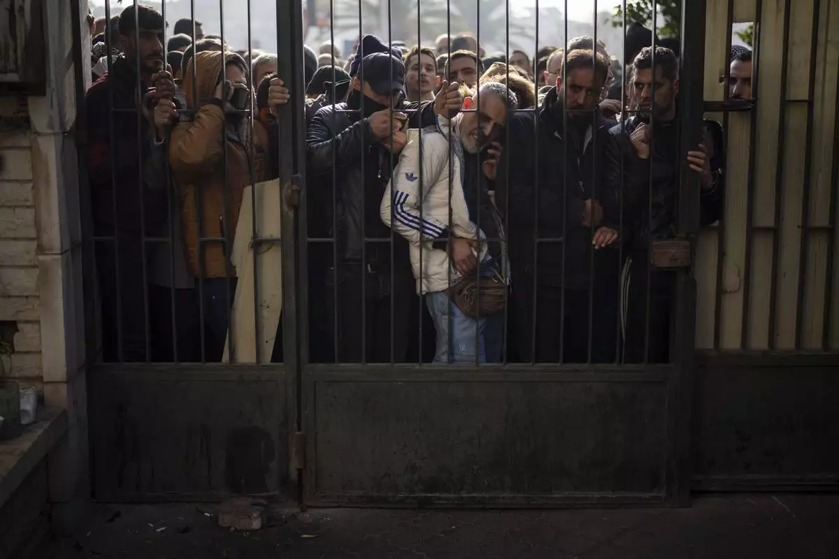 Members of Bashar Assad's army or a pro-government militia, gather to be registered with Syrian rebels as part of an "identification and reconciliation process" in Damascus, Syria, Saturday, Dec. 21, 2024. (AP Photo/Leo Correa)