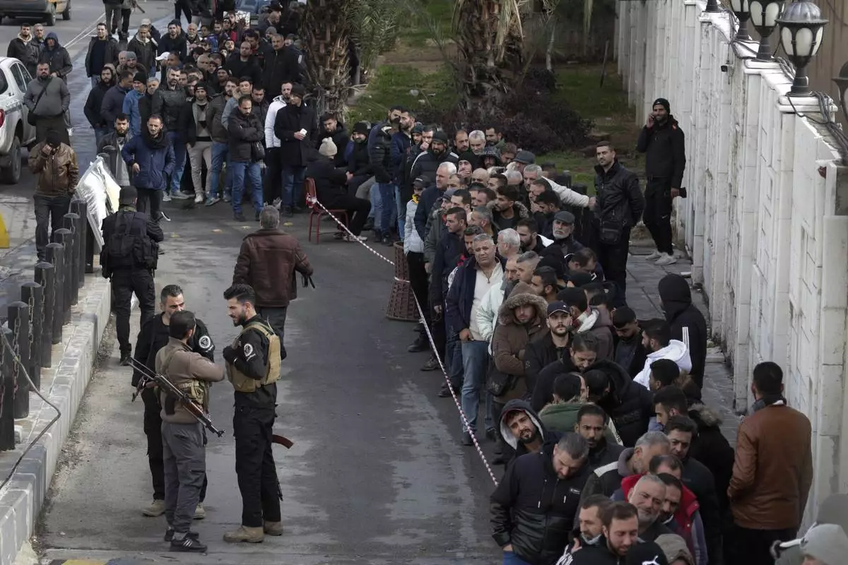 Members of Bashar Assad's army, or pro-government militia, line up to register with the newly formed Syrian government as part of an "identification and reconciliation" process in Damascus, Syria, Monday, Dec. 30, 2024. (AP Photo/Omar Sanadiki)