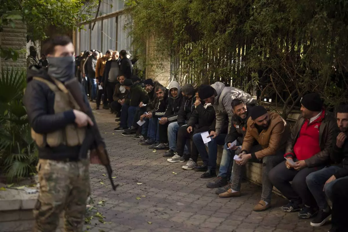 Members of Bashar Assad's army, or a pro-government militia, line up to register with Syrian rebels as part of an "identification and reconciliation process" in Damascus, Syria, Saturday, Dec. 21, 2024. (AP Photo/Leo Correa)