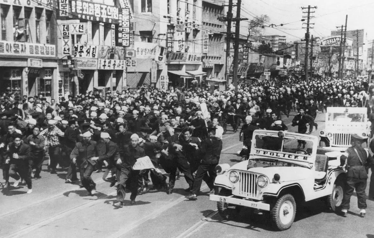 FILE- Students hurl rocks and shout slogans at the police in defiance of a government ban on demonstrations in South Korea, on Monday, April 18, 1960. (AP Photo/File)