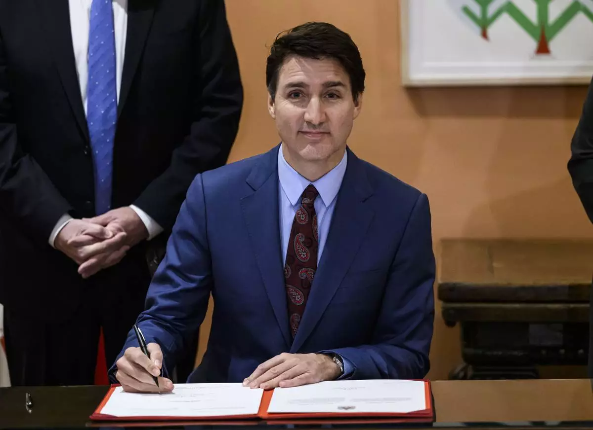 Canada's Prime Minister Justin Trudeau participates in a signing after Dominic LeBlanc, not shown, was sworn in as Finance Minister at a ceremony at Rideau Hall in Ottawa, Ontario, Monday, Dec. 16, 2024. (Justin Tang/The Canadian Press via AP)