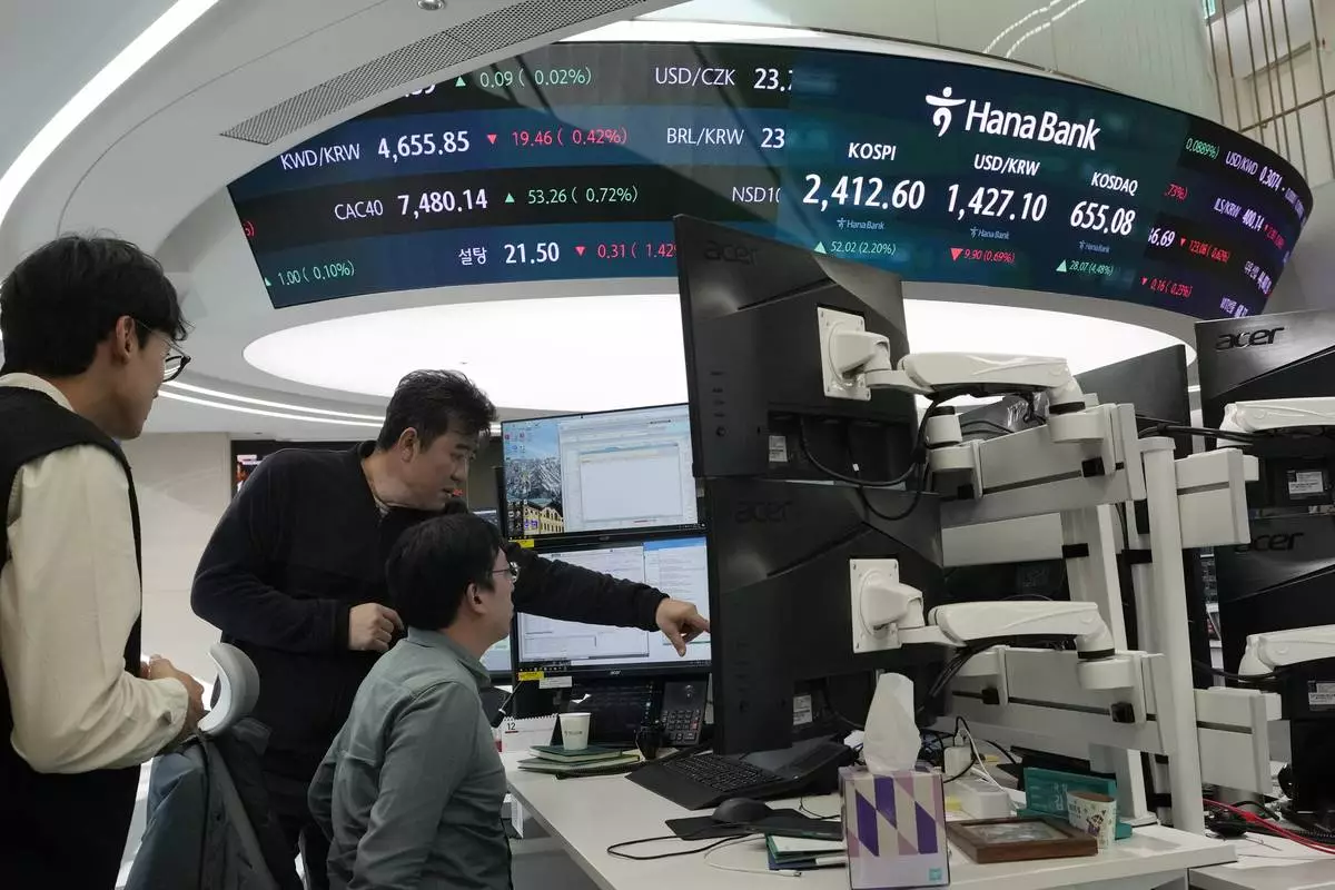 Currency traders work at the foreign exchange dealing room of the KEB Hana Bank headquarters in Seoul, South Korea, Tuesday, Dec. 10, 2024. (AP Photo/Ahn Young-joon)