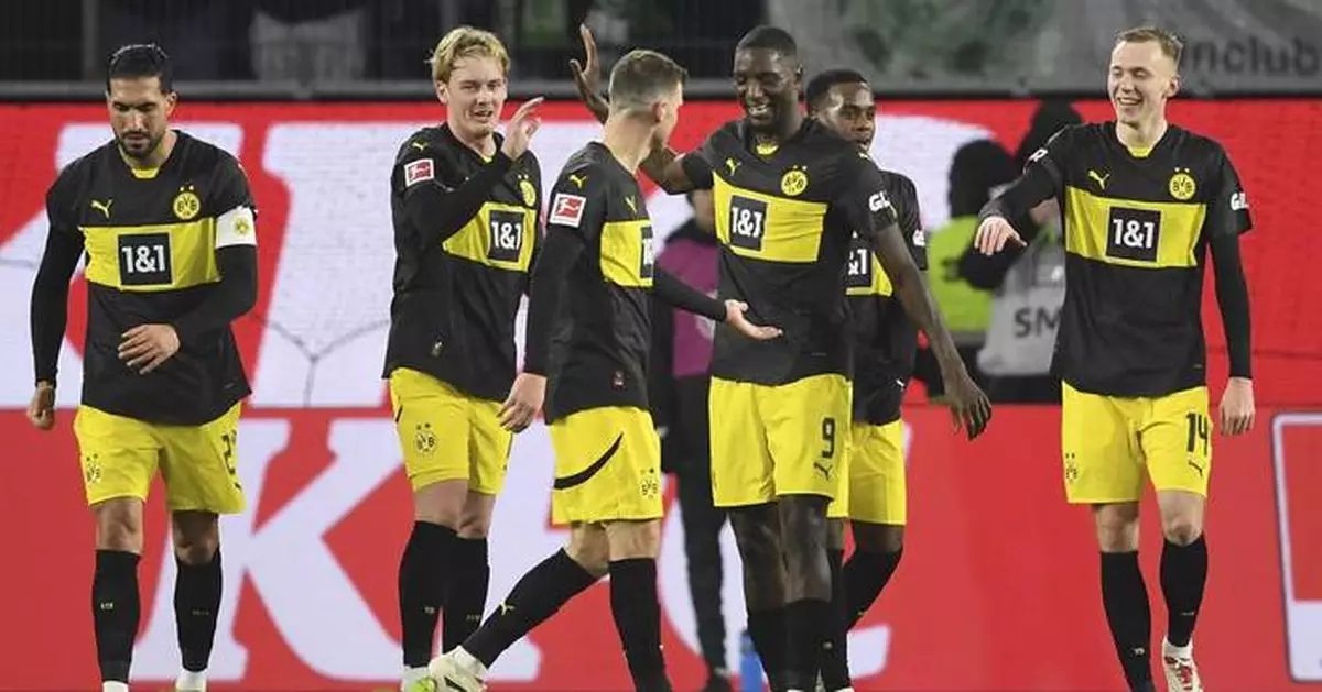 Dortmund holds on with 10 men for 1st away win in Bundesliga