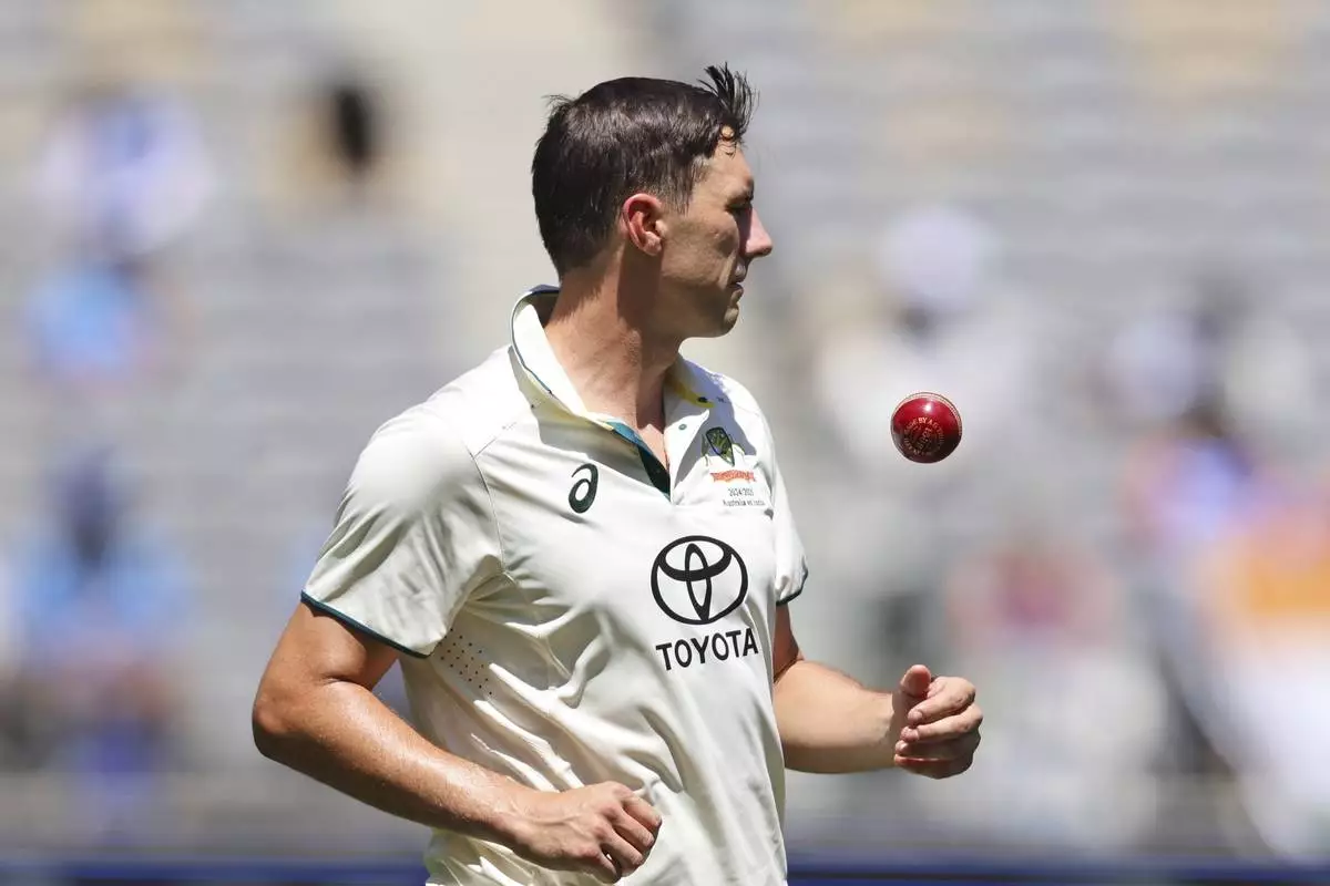 Australia's captain Pat Cummins tosses the ball as he prepares to bowl on the third day of the first cricket test between Australia and India in Perth, Australia, Sunday, Nov. 24, 2024. (AP Photo/Trevor Collens)