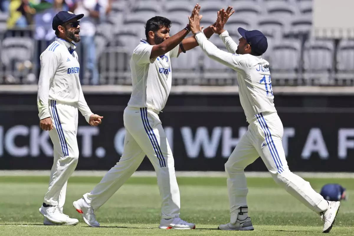 India's captain Jasprit Bumrah, center, celebrates with teammate Dhruv Jurel the wicket of Australia's Travis Head on the fourth day of the first cricket test between Australia and India in Perth, Australia, Monday, Nov. 25, 2024. (AP Photo/Trevor Collens)