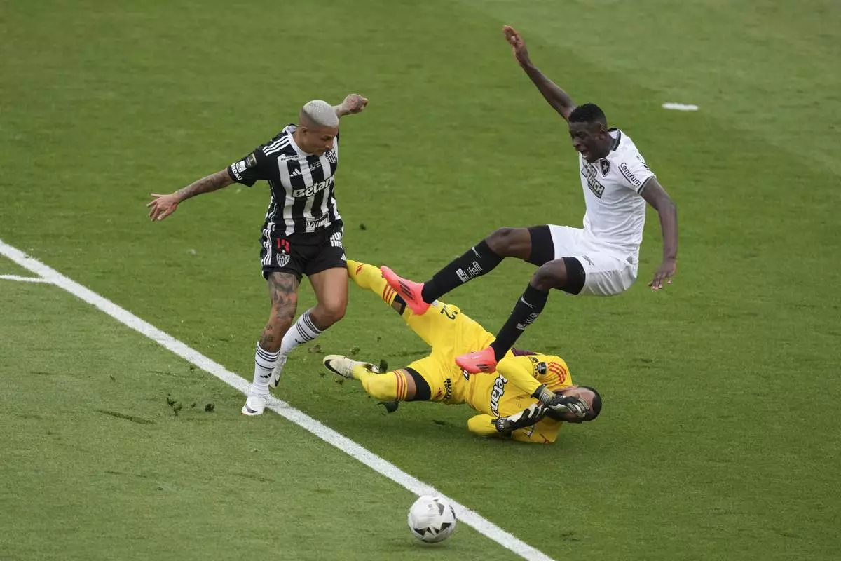 Luiz Henrique of Brazil's Botafogo, right. is fouled by goalkeeper Everson of Brazil's Atletico Mineiro inside the penalty area during a Copa Libertadores final soccer match at Monumental stadium in Buenos Aires, Argentina, Saturday, Nov. 30, 2024. (AP Photo/Natacha Pisarenko)