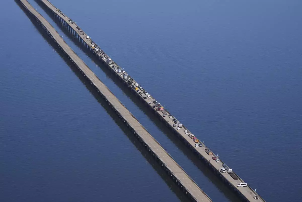 Disabled vehicles and response vehicles are seen on the Lake Pontchartrain Causeway, which spans 24 miles over the lake, after a pileup due to morning fog in New Orleans, Tuesday, Dec. 17, 2024. (AP Photo/Gerald Herbert)