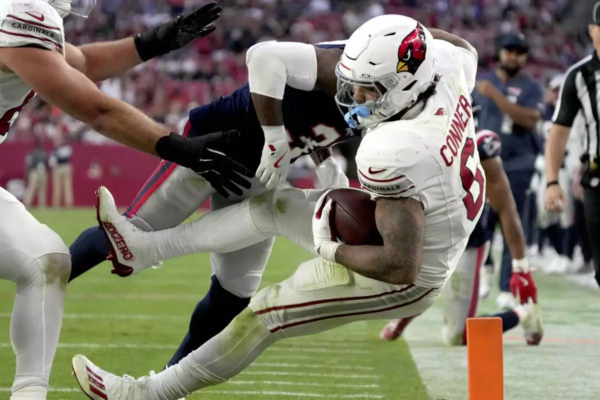 New England Patriots cornerback Jonathan Jones tackles Arizona Cardinals running back James Conner (6) during the second half of an NFL football game, Sunday, Dec. 15, 2024, in Glendale, Ariz. (AP Photo/Rick Scuteri)