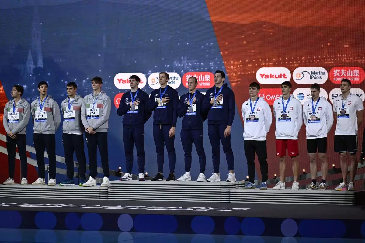 From left, second-placed Italy, first-placed United States, and third-placed Poland teams stand on the podium after the 4x100 meter freestyle final during the World Short Course Swimming Championships in Budapest, Hungary, Tuesday, Dec. 10, 2024. (AP Photo/Denes Erdos)