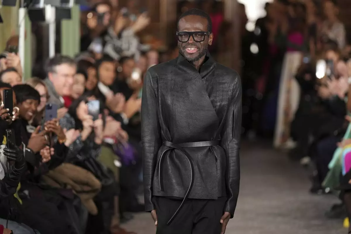 Fashion designer Imane Ayissi accepts applauses after his Haute Couture Spring Summer 2025 collection, that was presented in Paris, Monday, Jan. 27, 2025. (AP Photo/Lewis Joly)
