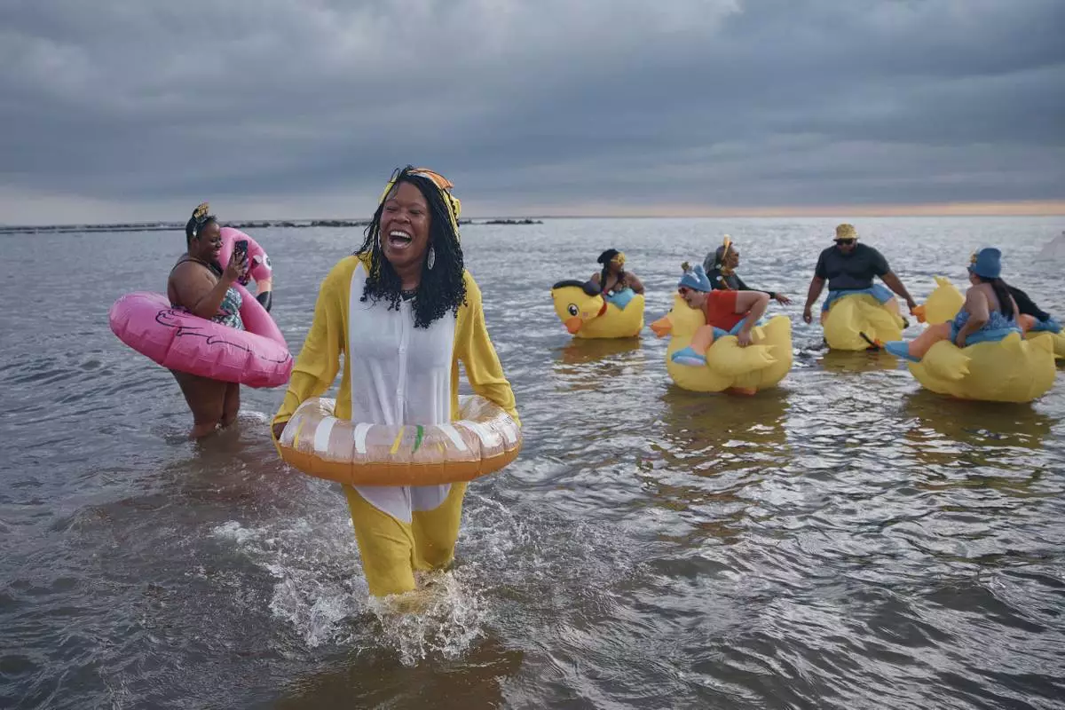 Revelers in costumes enter the cold water during the annual Polar Bear Plunge on New Year's Day, Wednesday, Jan. 1, 2025, in New York. (AP Photo/Andres Kudacki)