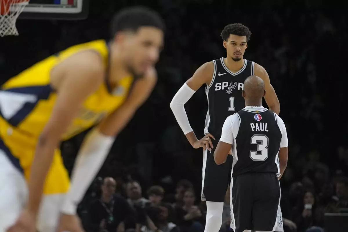 San Antonio Spurs center Victor Wembanyama (1) talks with guard Chris Paul (3) during the second half of a Paris Games 2025 NBA basketball game against the Indiana Pacers in Paris, Saturday, Jan. 25, 2025. (AP Photo/Thibault Camus)