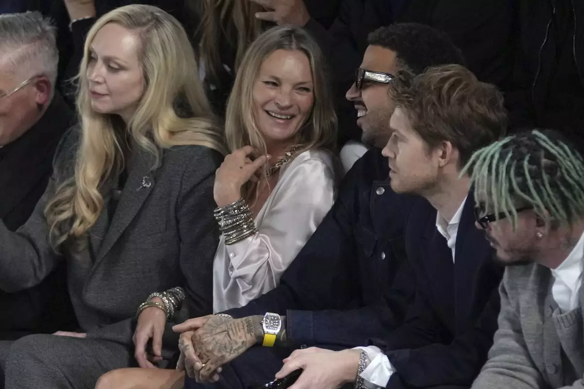 Gwendoline Christie, left, Kate Moss, center, Miles Chamley-Watson and Joe Alwyn, second right, attend the men's Dior Homme Fall-Winter 2025-2026 collection, that was presented in Paris, Friday, Jan. 24, 2025. (AP Photo/Thibault Camus)