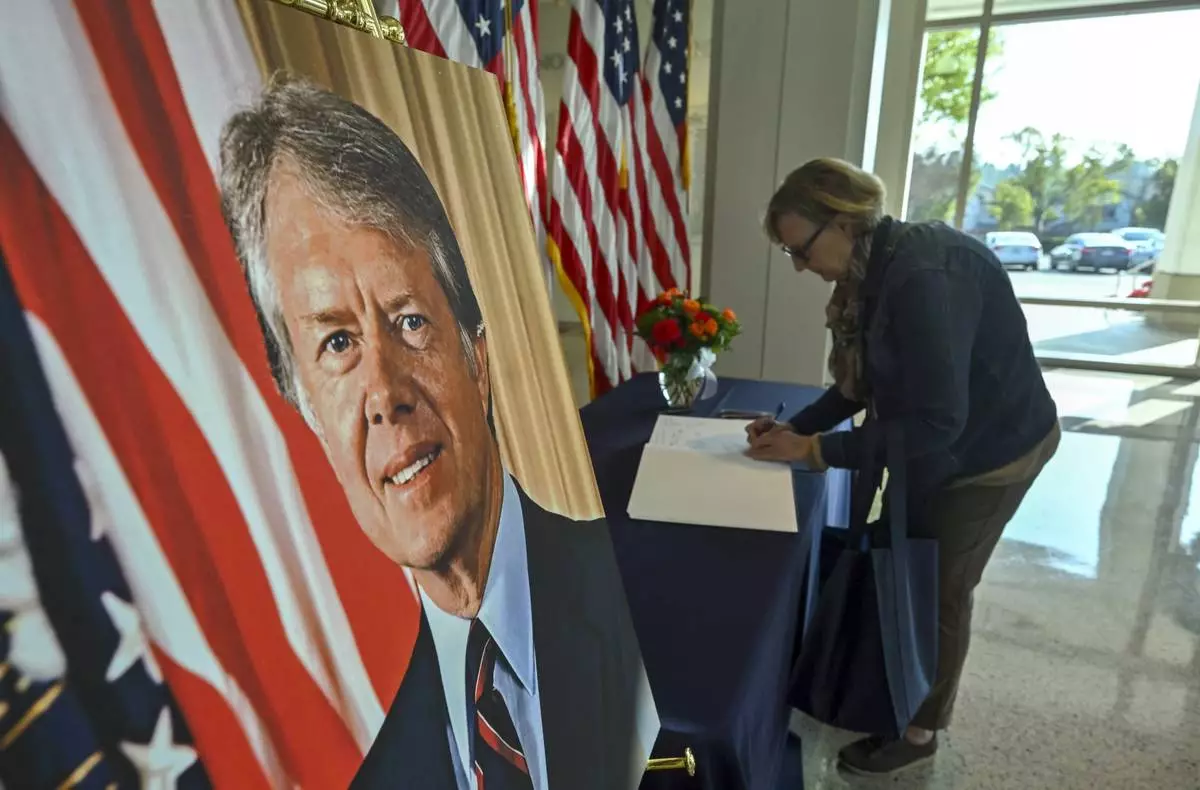 Chris Mapes, from Iowa, signs a condolence book for former President Jimmy Carter who died on Sunday, in the lobby of the The Richard Nixon Presidential Library &amp; Museum in Yorba Linda, Calif., Monday, Dec. 30, 2024. (Jeff Gritchen/The Orange County Register via AP)