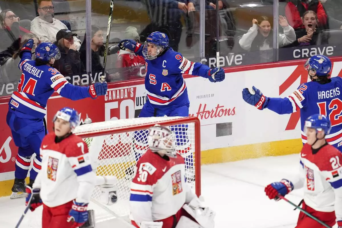 United States forward Ryan Leonard (9) celebrates after his goal with teammates Gabe Perreault (34) and James Hagens (12) during third-period World Junior hockey championship semifinal game action against Czechia in Ottawa, Ontario, Saturday, Jan. 4, 2025. (Sean Kilpatrick/The Canadian Press via AP)