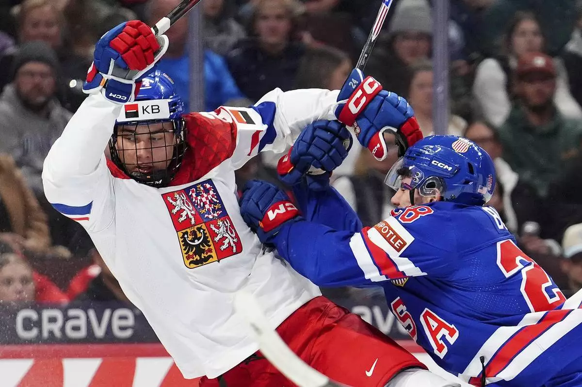 United States defenseman Zeev Buium (28) shoves Czechia forward Adam Novotny, left, during second-period World Junior hockey championship semifinal game action in Ottawa, Ontario, Saturday, Jan. 4, 2025. (Sean Kilpatrick/The Canadian Press via AP)