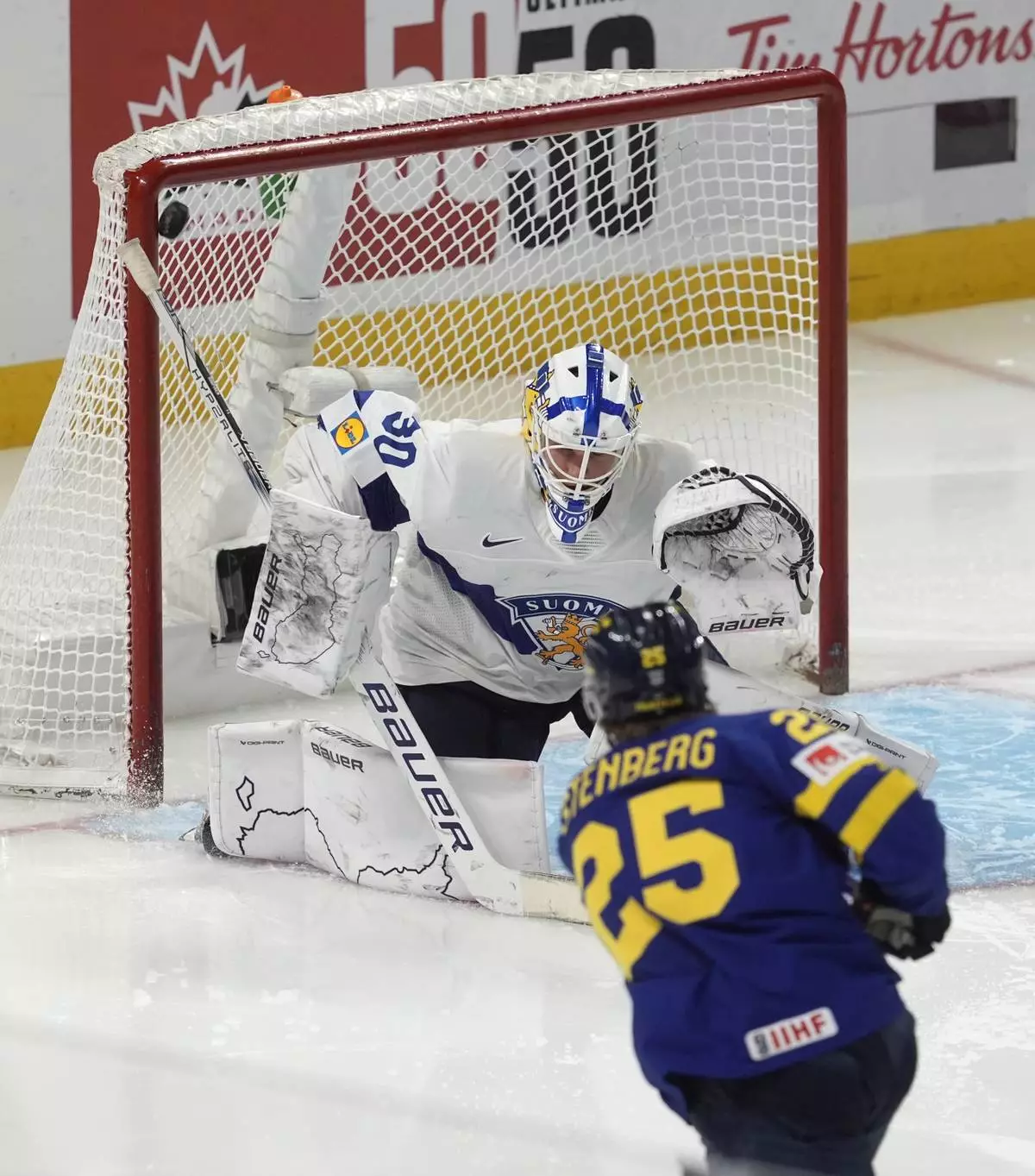 Sweden forward Otto Stenberg (25) scores on Finland goaltender Petteri Rimpinen (30) during second period semifinal IIHF World Junior Hockey Championship tournament action on Saturday, Jan. 4, 2025 in Ottawa. (Adrian Wyld/The Canadian Press via AP)