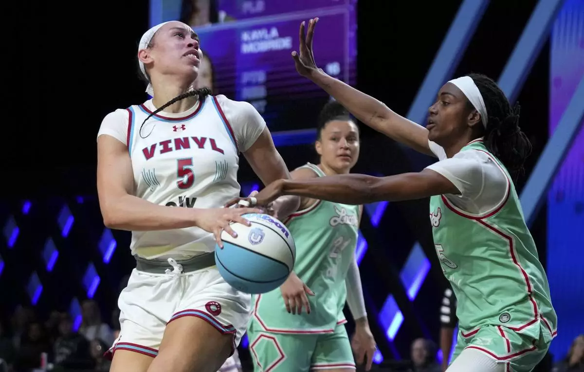 Vinyl forward Dearica Hamby (5) goes to the basket as Laces guard Tiffany Hayes, right, defends during the second half of an Unrivaled 3-on-3 basketball game Friday, Jan. 24, 2025, in Medley, Fla. (AP Photo/Lynne Sladky)