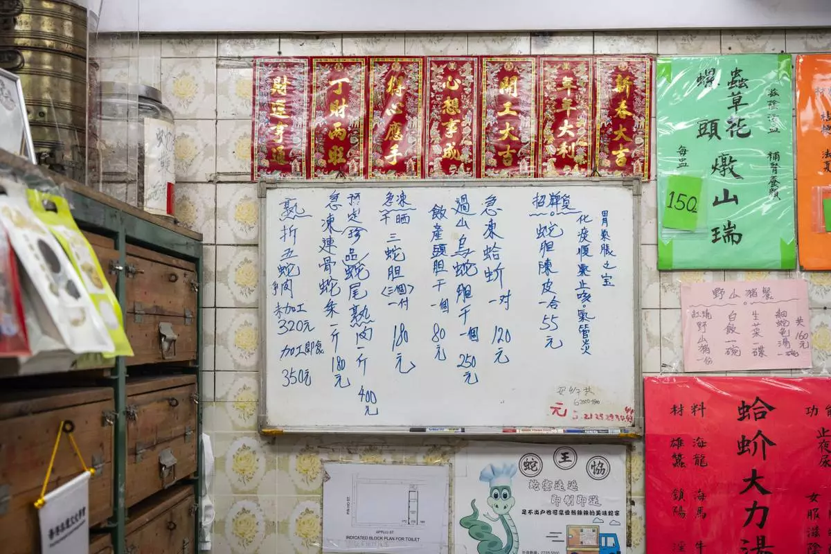 A handwritten menu hangs on the wall inside the family-run snake soup restaurant in Hong Kong, Monday, Jan. 6, 2025. (AP Photo/Chan Long Hei)