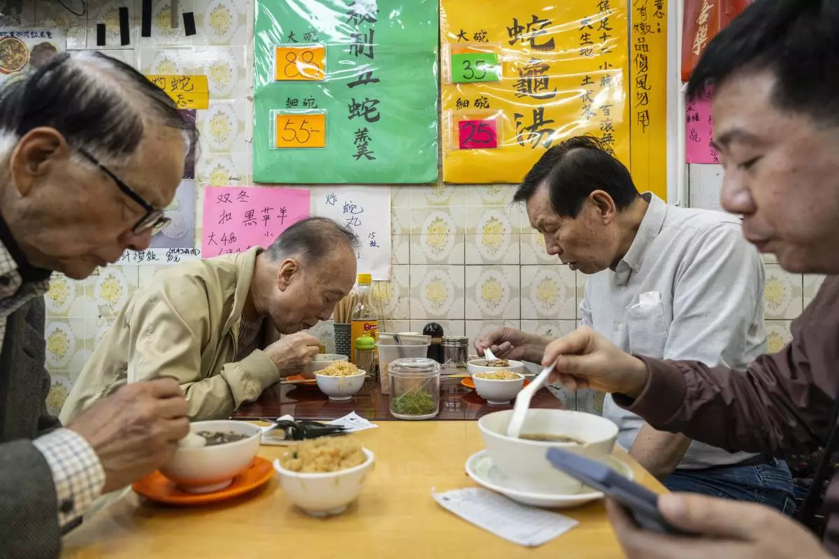 Customers dine at the family-run snake soup restaurant in Hong Kong, Monday, Jan. 6, 2025. (AP Photo/Chan Long Hei)