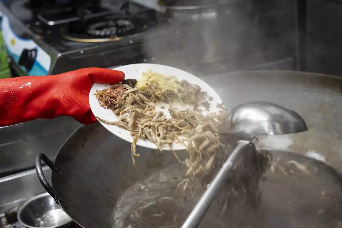 Chau Ka-ling, owner of the family-run snake soup restaurant, prepares snake soup in Hong Kong, Monday, Jan. 6, 2025. (AP Photo/Chan Long Hei)