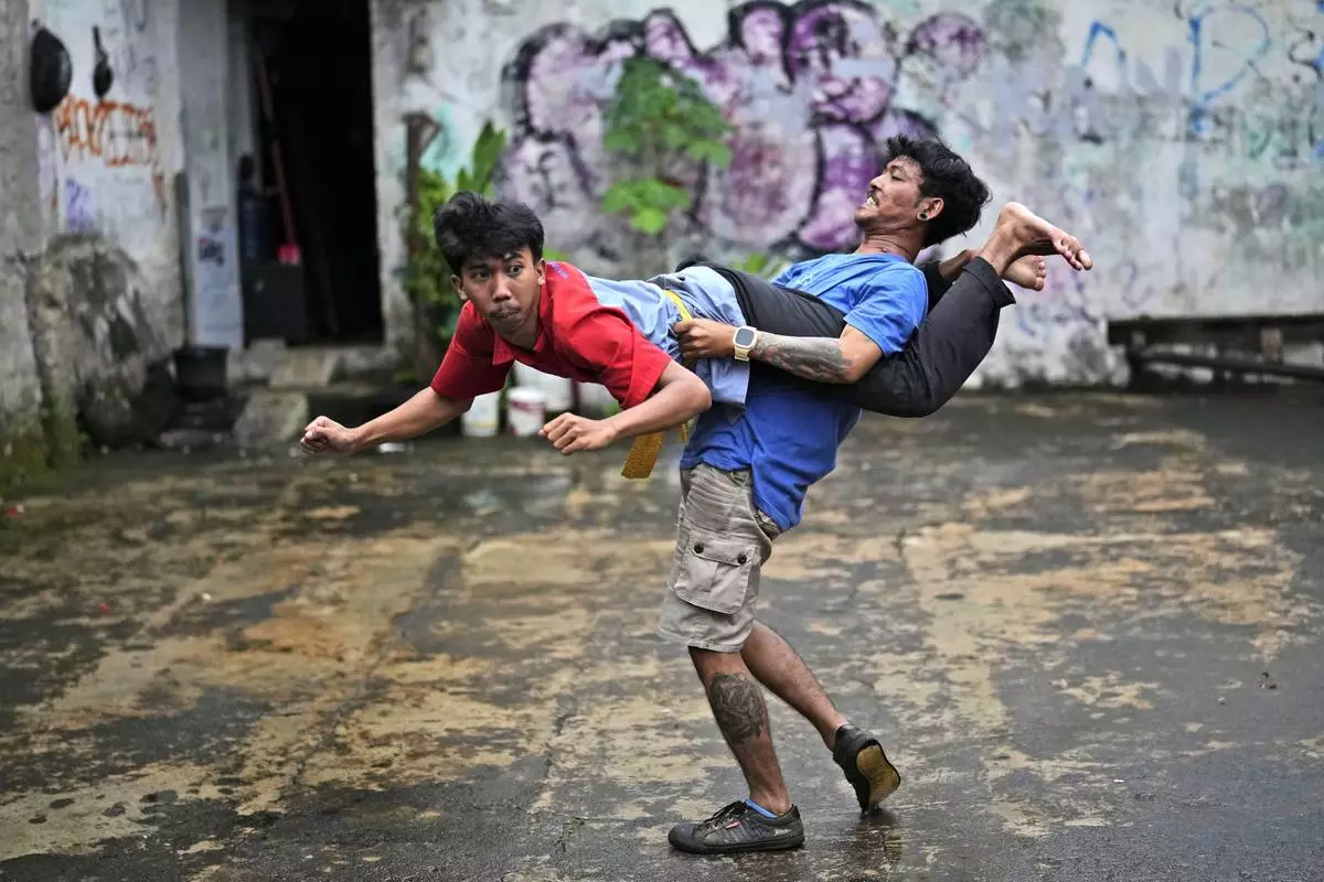 Muhammad Hisyam, left, and Aji Permana, members of dragon dance club Naga Merah Putih (Red White Dragon) which is named after Indonesian national colors, practice in Bogor, West Java, Indonesia, Friday, Jan. 24, 2025. (AP Photo/Dita Alangkara)