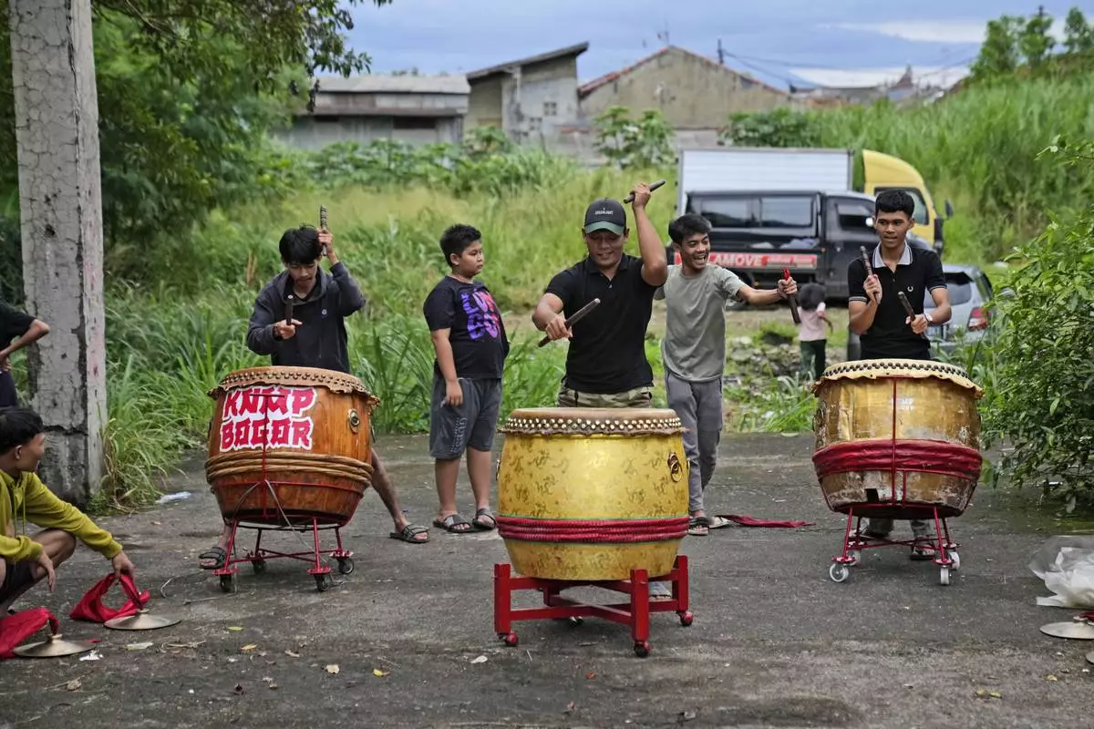 Members of dragon dance club Naga Merah Putih (Red White Dragon), named after Indonesian national colors, practice drumming days ahead of a performance, in Bogor, West Java, Indonesia, Wednesday, Jan. 22, 2025. (AP Photo/Dita Alangkara)