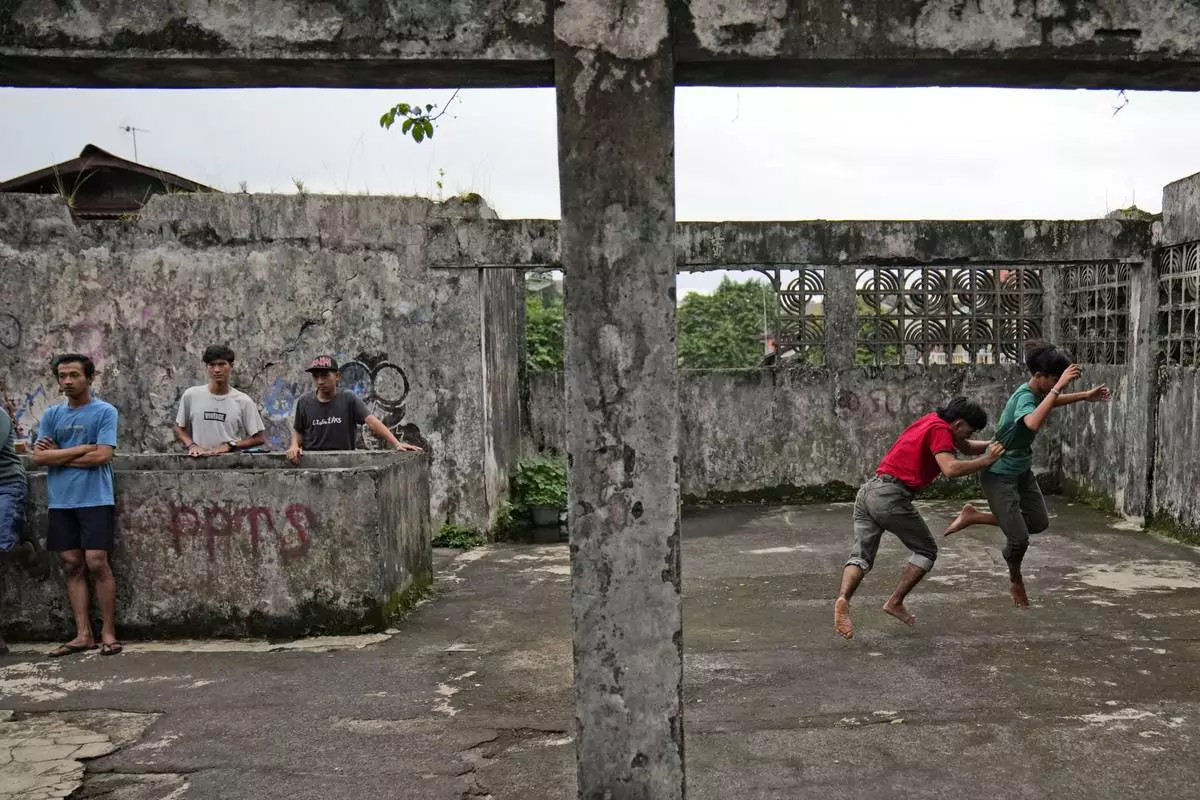 Members of dragon dance club Naga Merah Putih (Red White Dragon) which is named after Indonesian national colors, Muhammad Ilman, second right, and Muhammad Fadil, right, practice their dance movements in Bogor, West Java, Indonesia, Wednesday, Jan. 22, 2025. (AP Photo/Dita Alangkara)