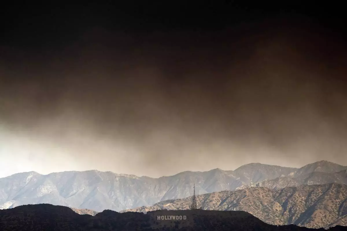 Thick heavy smoke from wildfires passes over the Hollywood sign in Los Angeles on Wednesday, Jan. 8, 2025. (AP Photo/Richard Vogel)