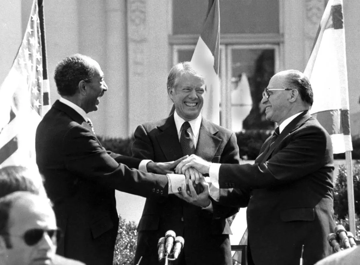 FILE - Egyptian President Anwar Sadat, left, U.S. President Jimmy Carter, center, and Israeli Prime Minister Menachem Begin clasp hands on the north lawn of the White House after signing the peace treaty between Egypt and Israel on March 26, 1979, in Washington. (AP Photo/ Bob Daugherty, File)