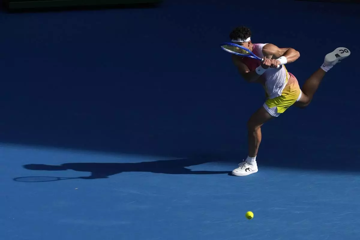 Ben Shelton of the U.S. plays a backhand return to Gael Monfils of France during their fourth round match at the Australian Open tennis championship in Melbourne, Australia, Monday, Jan. 20, 2025. (AP Photo/Manish Swarup)