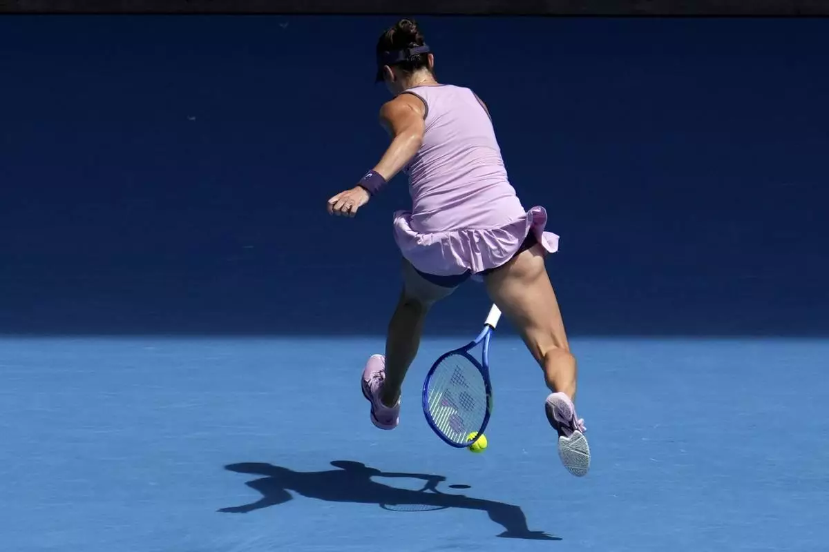 Belinda Bencic of Switzerland returns a shot between legs to Coco Gauff of the U.S. during their fourth round match at the Australian Open tennis championship in Melbourne, Australia, Sunday, Jan. 19, 2025. (AP Photo/Mark Baker)