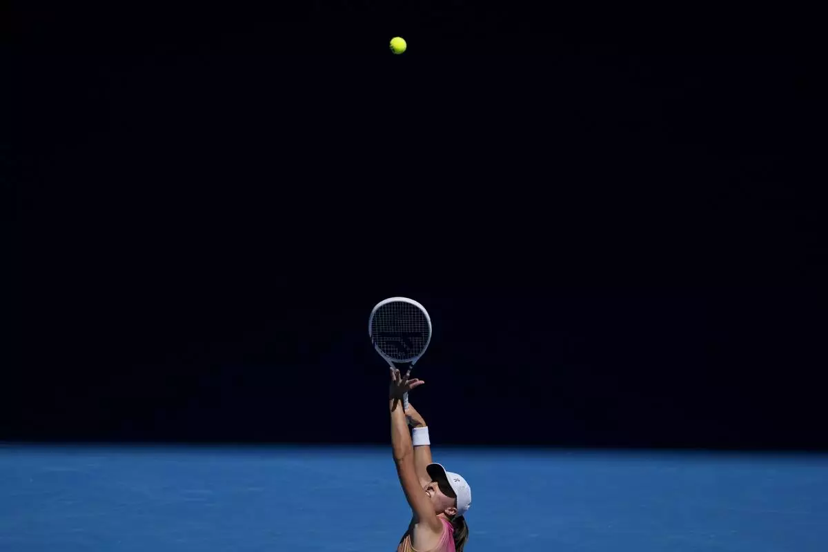 Iga Swiatek of Poland serves to Emma Navarro of the U.S. during their quarterfinal match at the Australian Open tennis championship in Melbourne, Australia, Wednesday, Jan. 22, 2025. (AP Photo/Ng Han Guan)
