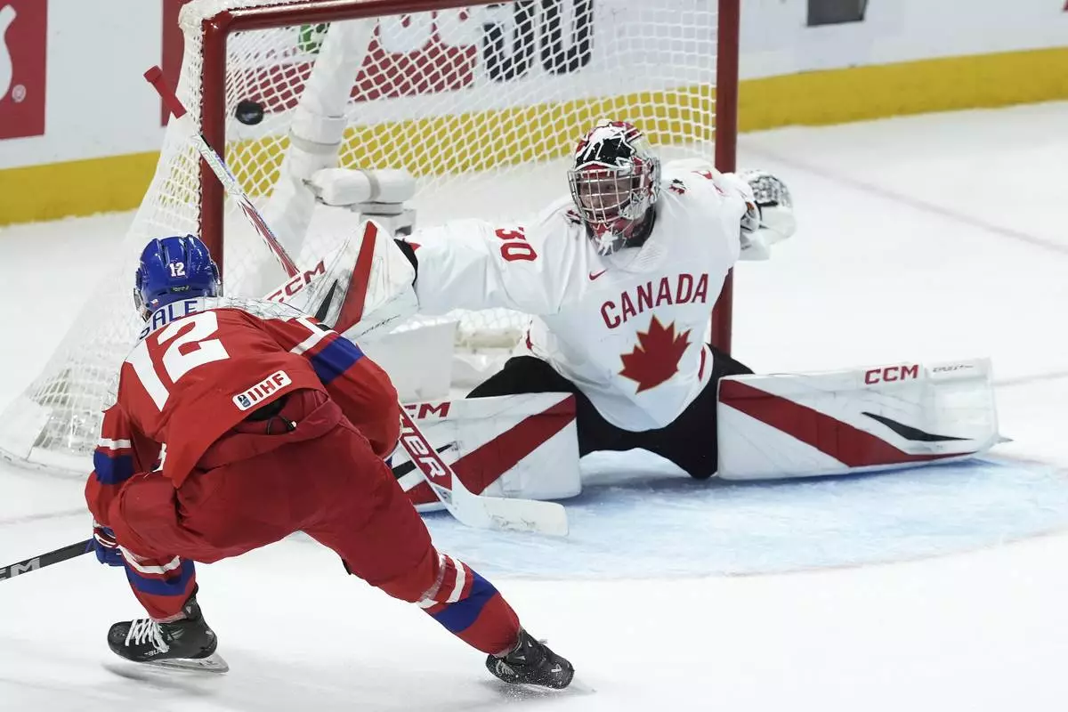 Czech Republic forward Eduard Sale (12) scores on Canada goalkeeper Carter George (30) during the first period of a quarterfinal match at the world junior hockey championship in Ottawa, Ontario, Thursday, Jan. 2, 2025. (Adrian Wyld/The Canadian Press via AP)