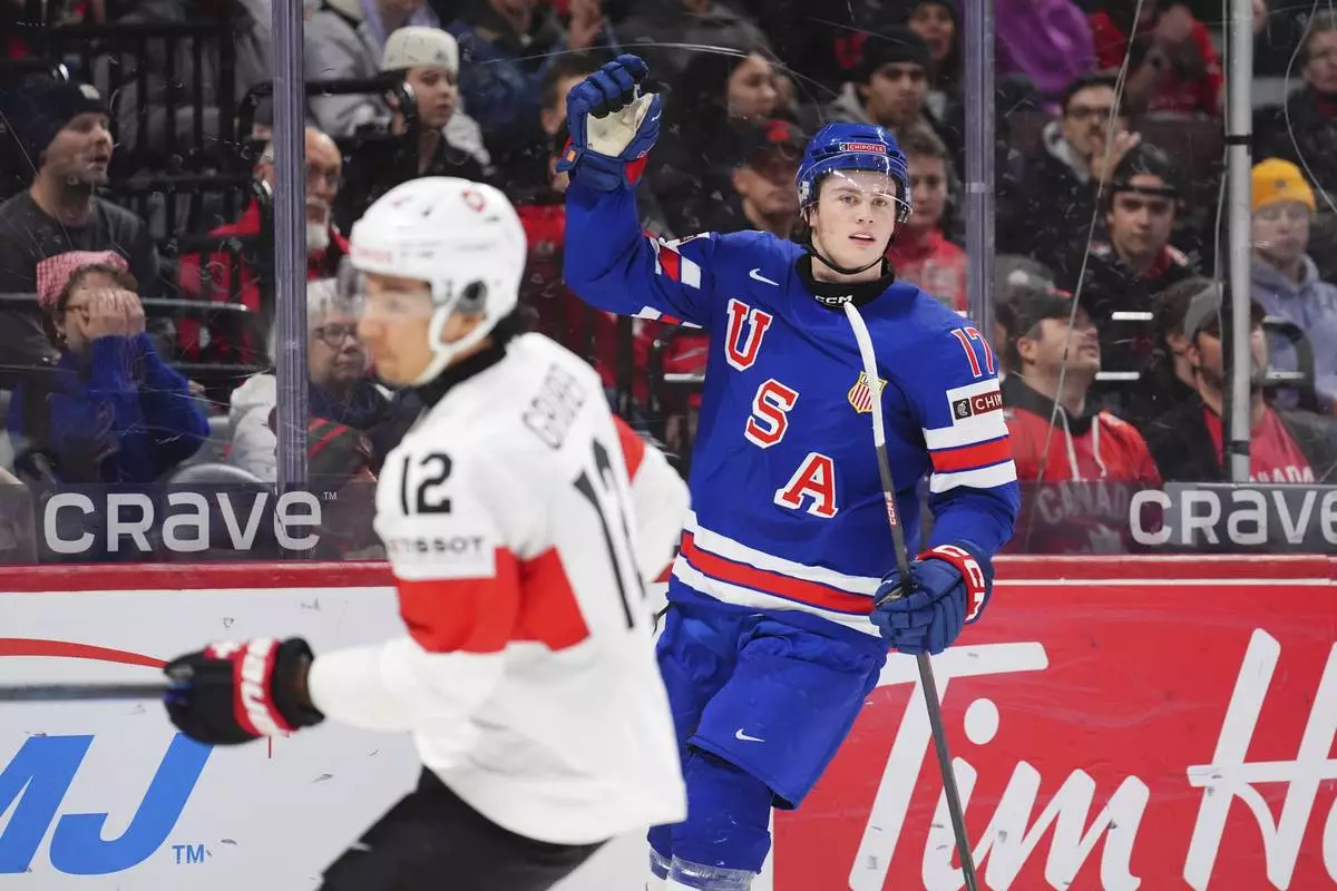 USA forward Danny Nelson (17) celebrates his goal as Switzerland forward Kimo Gruber (12) skates by during the first period of a quarterfinal match at the IIHF World Junior Hockey Championship in Ottawa, Ontario Thursday, Jan. 2, 2025. (Sean Kilpatrick/The Canadian Press via AP)