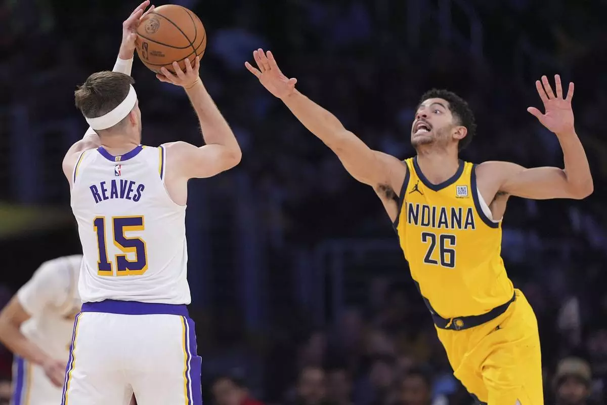 Los Angeles Lakers guard Austin Reaves, left, shoots and scores as Indiana Pacers guard Ben Sheppard defends during the second half of an NBA basketball game, Saturday, Feb. 8, 2025, in Los Angeles. (AP Photo/Mark J. Terrill)