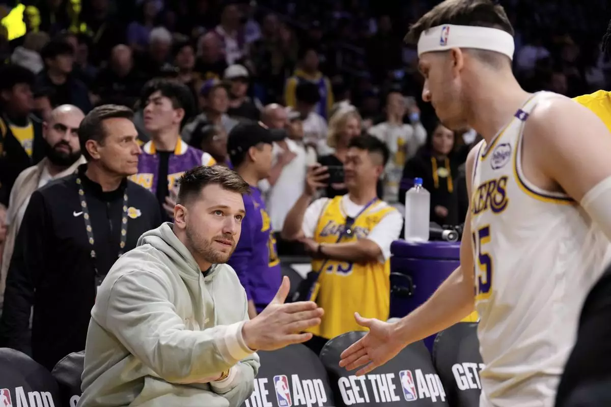 Los Angeles Lakers' Luka Doncic, left, greets guard Austin Reaves prior to an NBA basketball game against the Indiana Pacers, Saturday, Feb. 8, 2025, in Los Angeles. (AP Photo/Mark J. Terrill)
