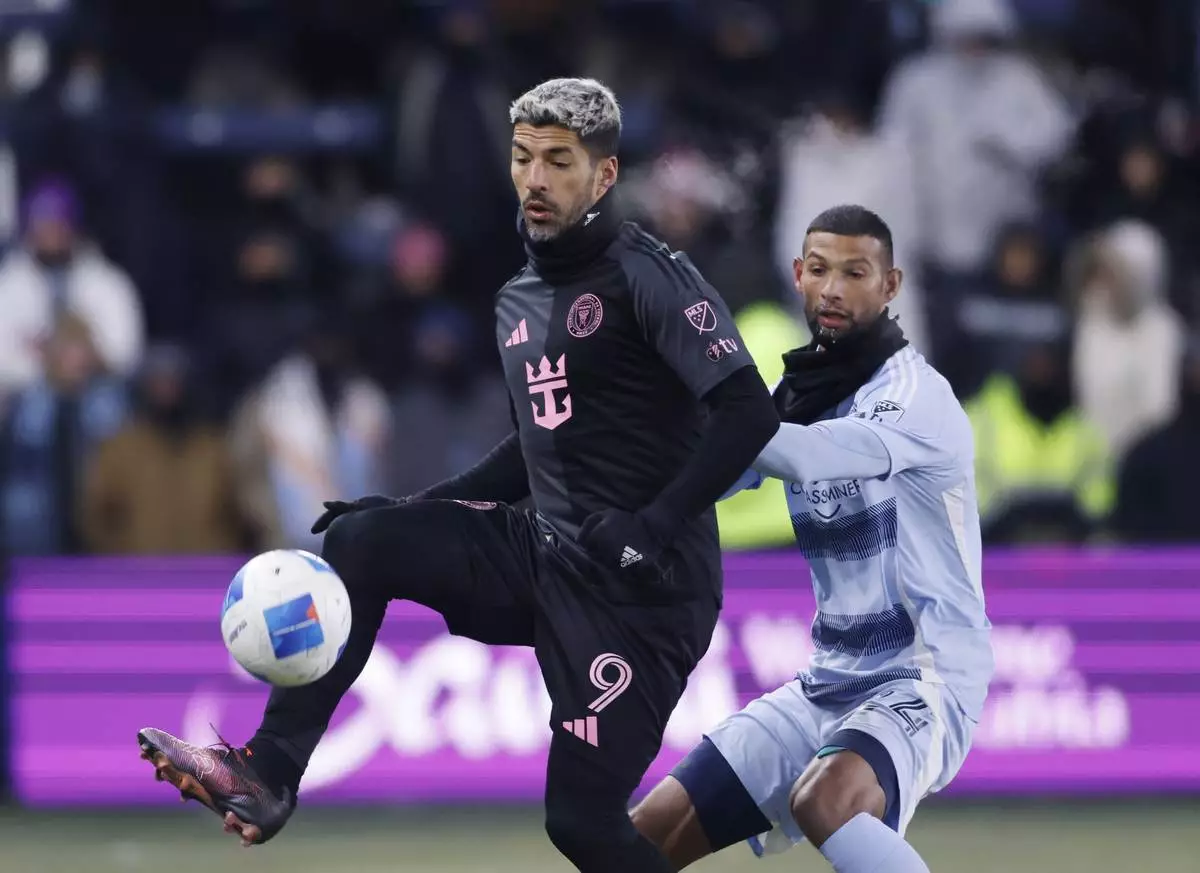 Inter Miami forward Luis Suárez (9) controls a pass as Sporting Kansas City defender Joaquín defends during the second half of a CONCACAF Champions Cup soccer match, Wednesday, Feb. 19, 2025, in Kansas City, Kan. (AP Photo/Colin E. Braley)