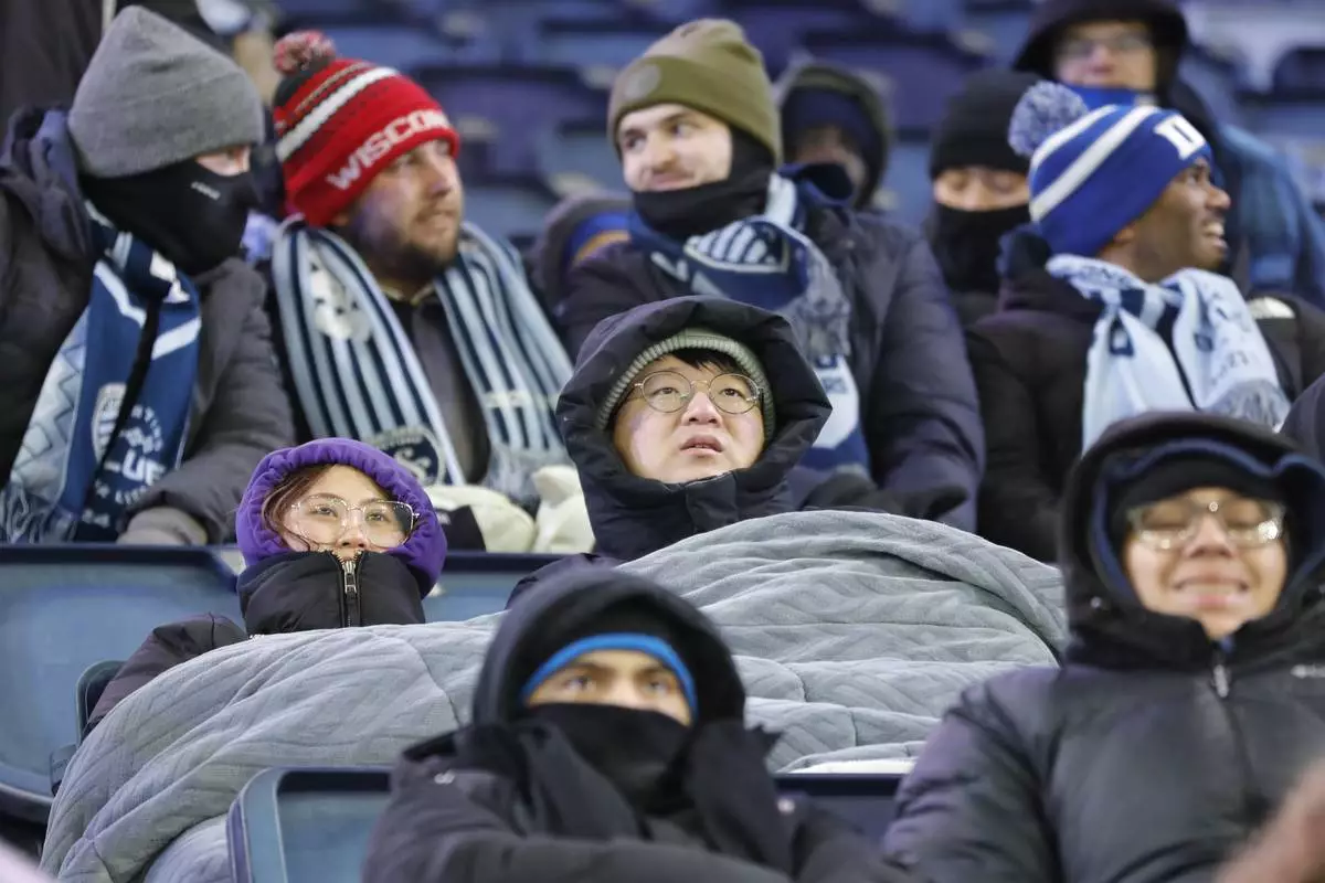 Fans brave frigid temperatures as they watch Inter Miami play Sporting Kansas City during a CONCACAF Champions Cup soccer match, Wednesday, Feb. 19, 2025, in Kansas City, Kan. (AP Photo/Colin E. Braley)