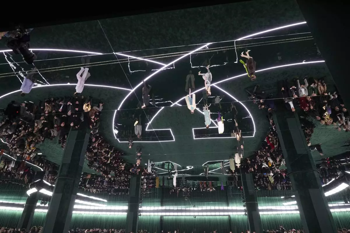 Models, reflected on the ceiling, wear creations as part of the Gucci Fall/Winter 2025-2026 men's and women's collection, presented in Milan, Italy, Tuesday, Feb. 25, 2025. (AP Photo/Luca Bruno)