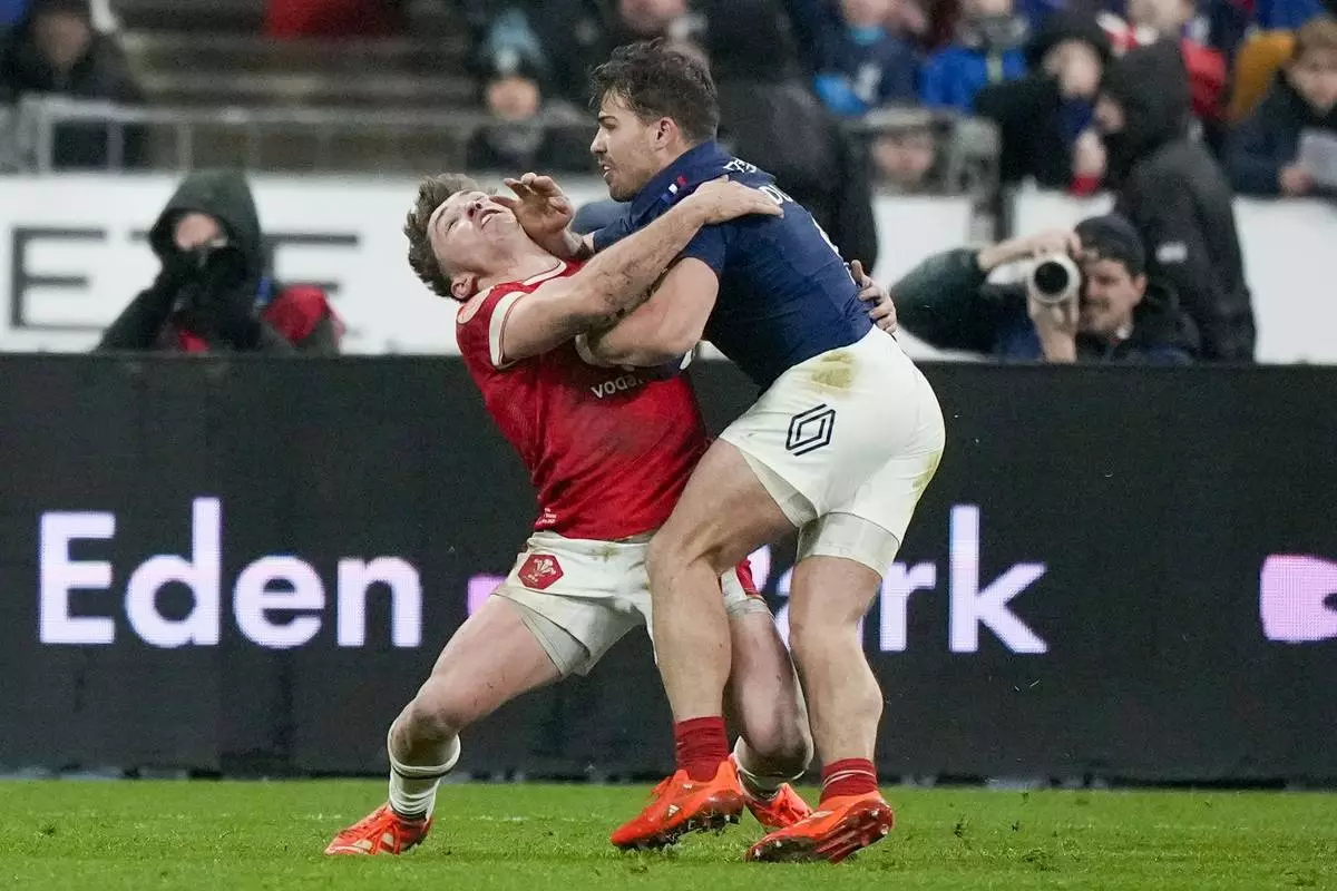 France's Antoine Dupont, right, tries to get to the line during the Six Nations rugby union match between France and Wales at the Stade de France in Saint-Denis, outside Paris, Friday, Jan. 31, 2025. (AP Photo/Michel Euler)