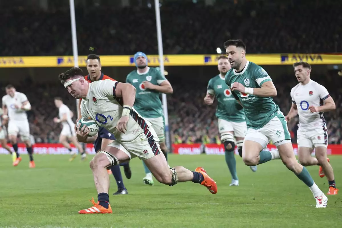 England's Tom Curry crosses the line to score a try during the Six Nations rugby union match between Ireland and England at the Aviva Stadium in Dublin, Saturday, Feb. 1, 2025. (AP Photo/Peter Morrison)