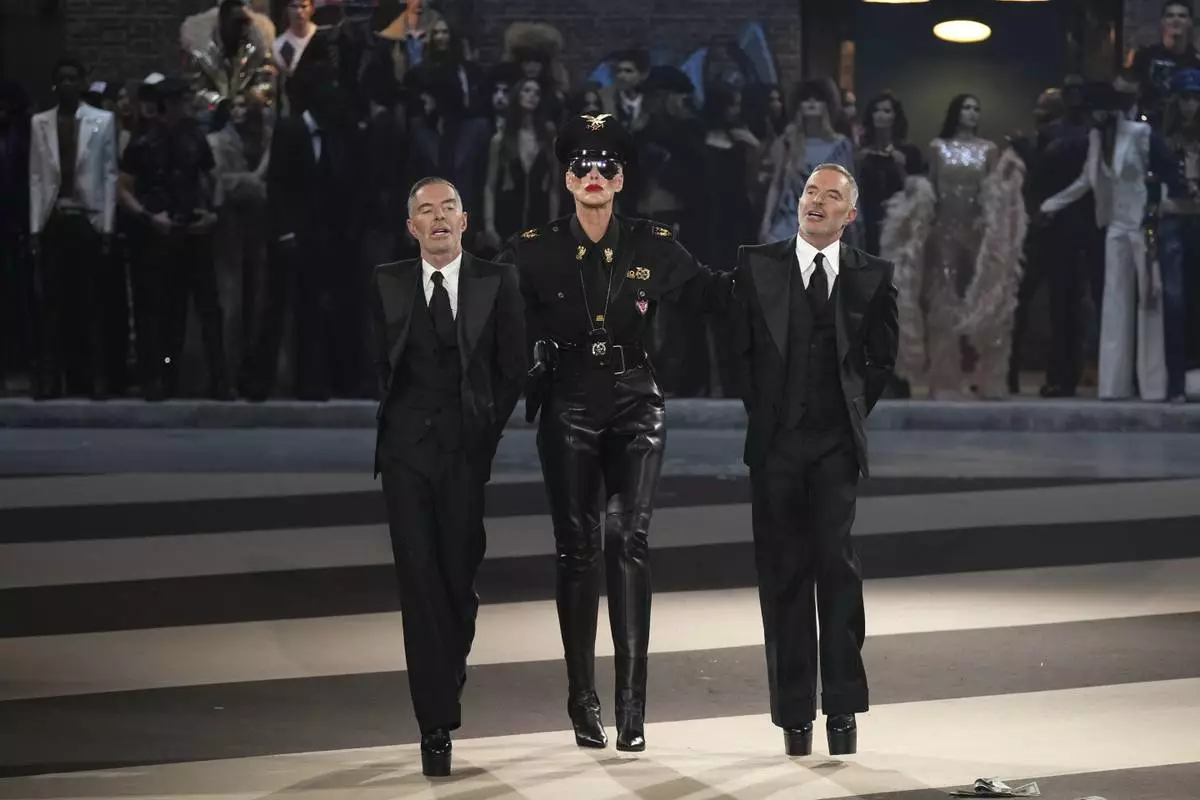 Denmark's actress Brigitte Nielsen, centre, walks with designers Dean Caten, left, and Dan Caten during the Dsquared2 Fall/Winter 2025-2026 men's and women's collection presented in Milan, Italy, Tuesday, Feb. 25, 2025. (AP Photo/Antonio Calanni)