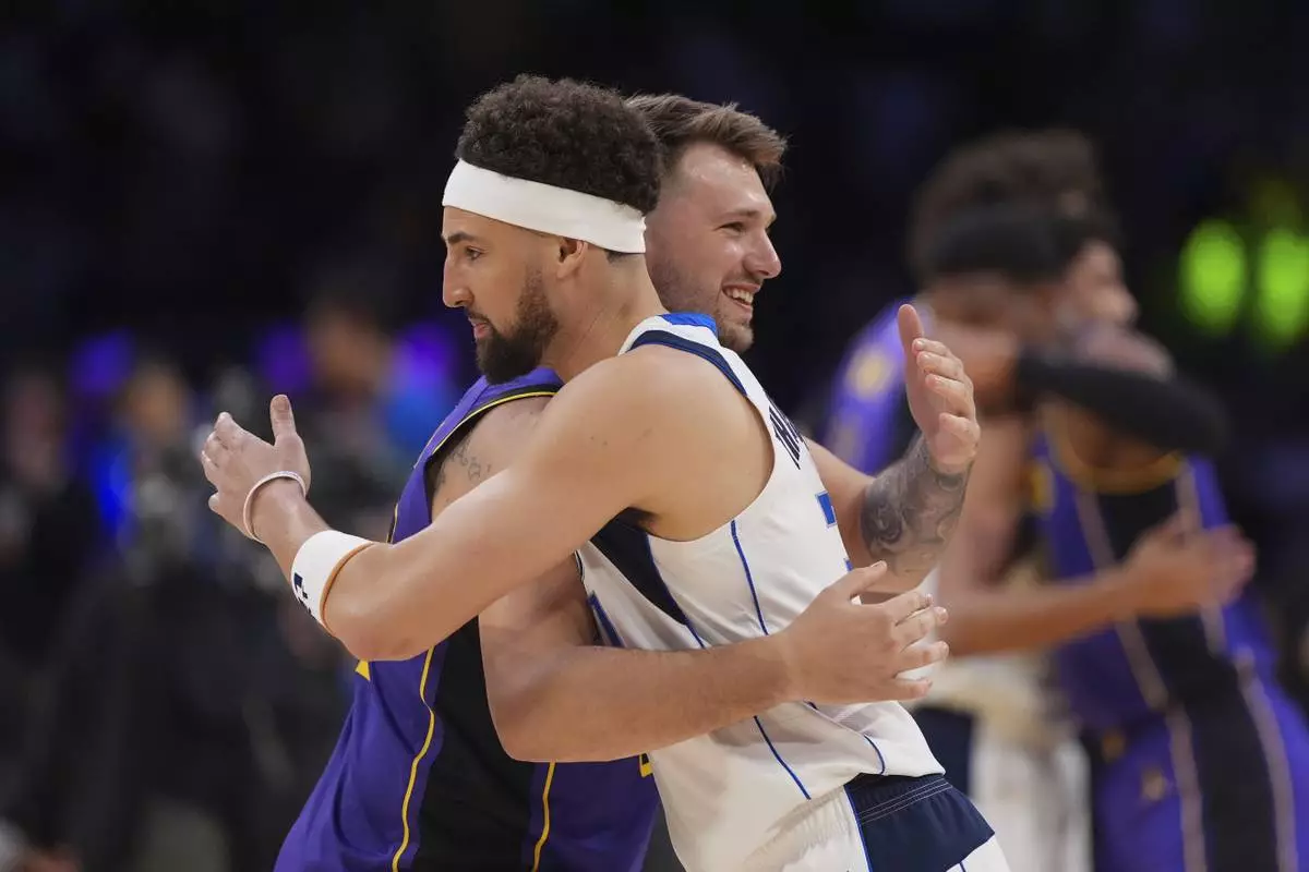 Los Angeles Lakers guard Luka Doncic, left, and Dallas Mavericks guard Klay Thompson hug before an NBA basketball game Tuesday, Feb. 25, 2025, in Los Angeles. (AP Photo/Mark J. Terrill)