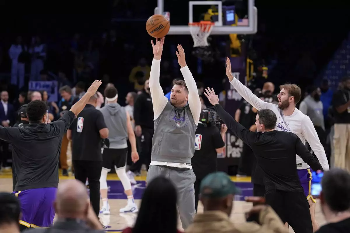 Los Angeles Lakers guard Luka Doncic, center, warms up before an NBA basketball game against the Dallas Mavericks, Tuesday, Feb. 25, 2025, in Los Angeles. (AP Photo/Mark J. Terrill)