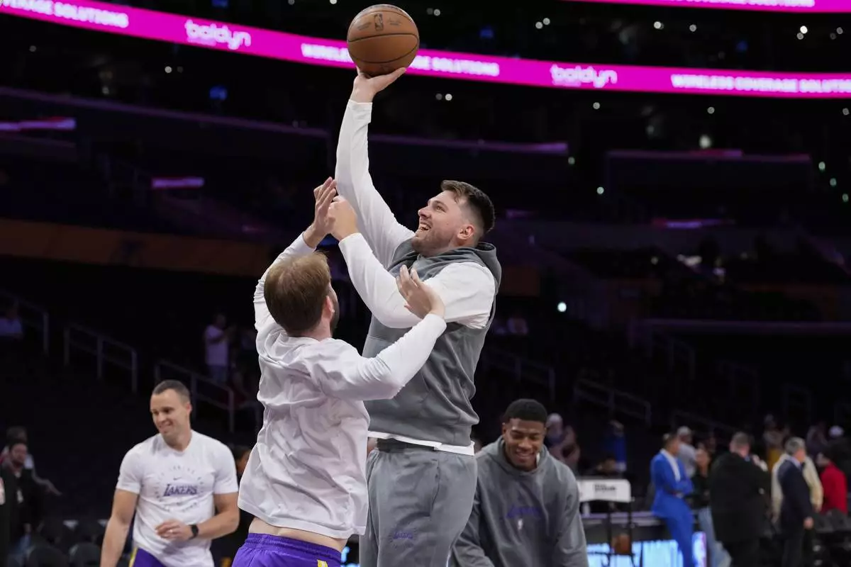 Los Angeles Lakers guard Luka Doncic, center right, warms up before an NBA basketball game against the Dallas Mavericks, Tuesday, Feb. 25, 2025, in Los Angeles. (AP Photo/Mark J. Terrill)