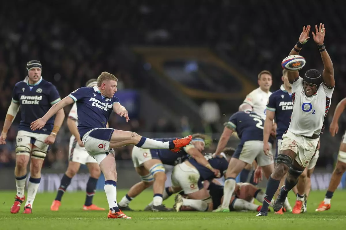 Scotland's Finn Russell clears the ball as England's Maro Itoje, right, tries to charge the ball down during the Six Nations rugby union match between England and Scotland at Twickenham in London, Saturday, Feb. 22, 2025. (AP Photo/Ian Walton)